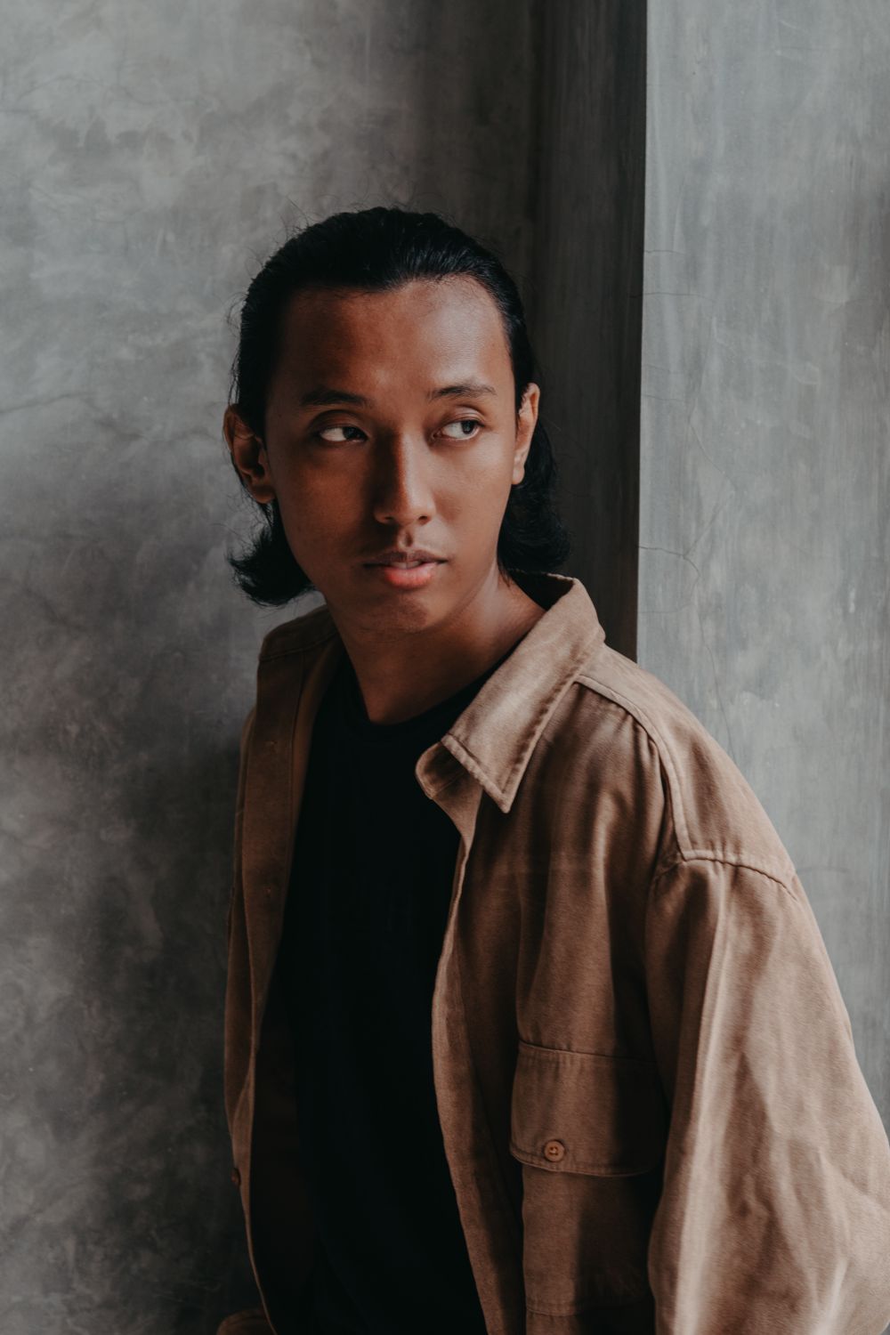 Man wearing a brown overshirt over a dark top